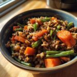 A bowl of homemade Beef and Rice Dog Food Recipe with carrots and green beans.