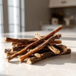 Pile of Beef and Vegetable Chew Sticks for Dogs on a white countertop with a bright background.