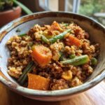 A bowl of homemade Crockpot Dog Food Recipe featuring ground meat, rice, carrots, and green beans.