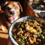 A bowl of Egg & Green Bean Dog Food Recipe with a dog looking eagerly in the background.
