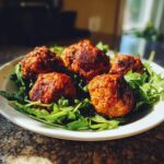 A plate of homemade Ground Chicken Meatballs for Dogs served on a bed of fresh arugula.