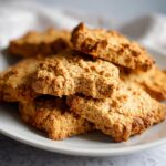 A stack of freshly baked Peanut Butter Yogurt Dog Treats on a white plate, ready to be enjoyed.