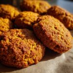 Close-up of freshly baked Pumpkin Oatmeal Dog Treats on parchment paper.
