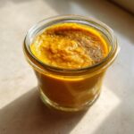 A jar filled with homemade Turmeric Golden Paste for Dogs, showcasing its vibrant color and smooth texture.