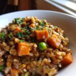 Close-up of a bowl of Wholesome Vegetarian Dog Meal with rice, lentils, carrots, and peas, garnished with parsley.