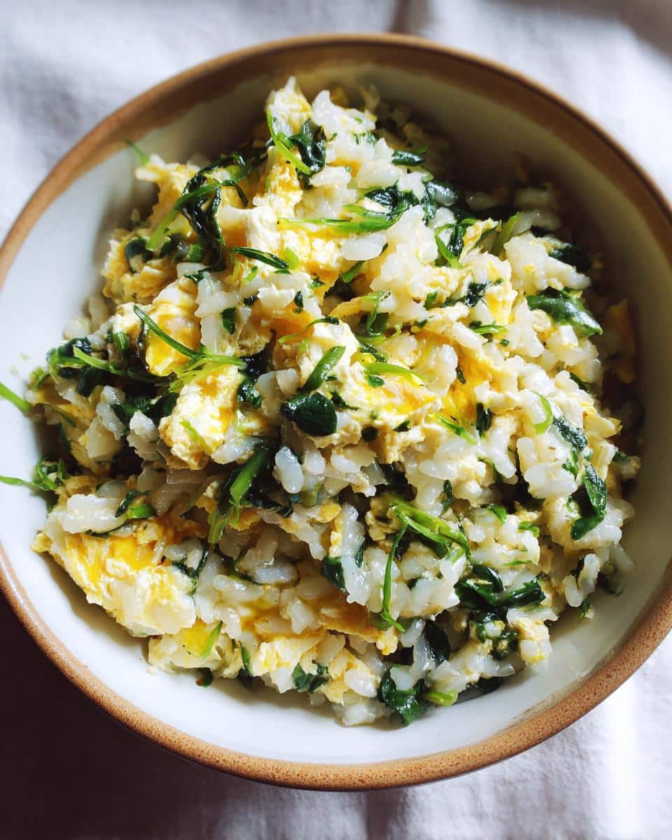 A bowl of the Best Egg & Spinach Dog Food Bowl recipe, featuring rice, scrambled eggs, and spinach.