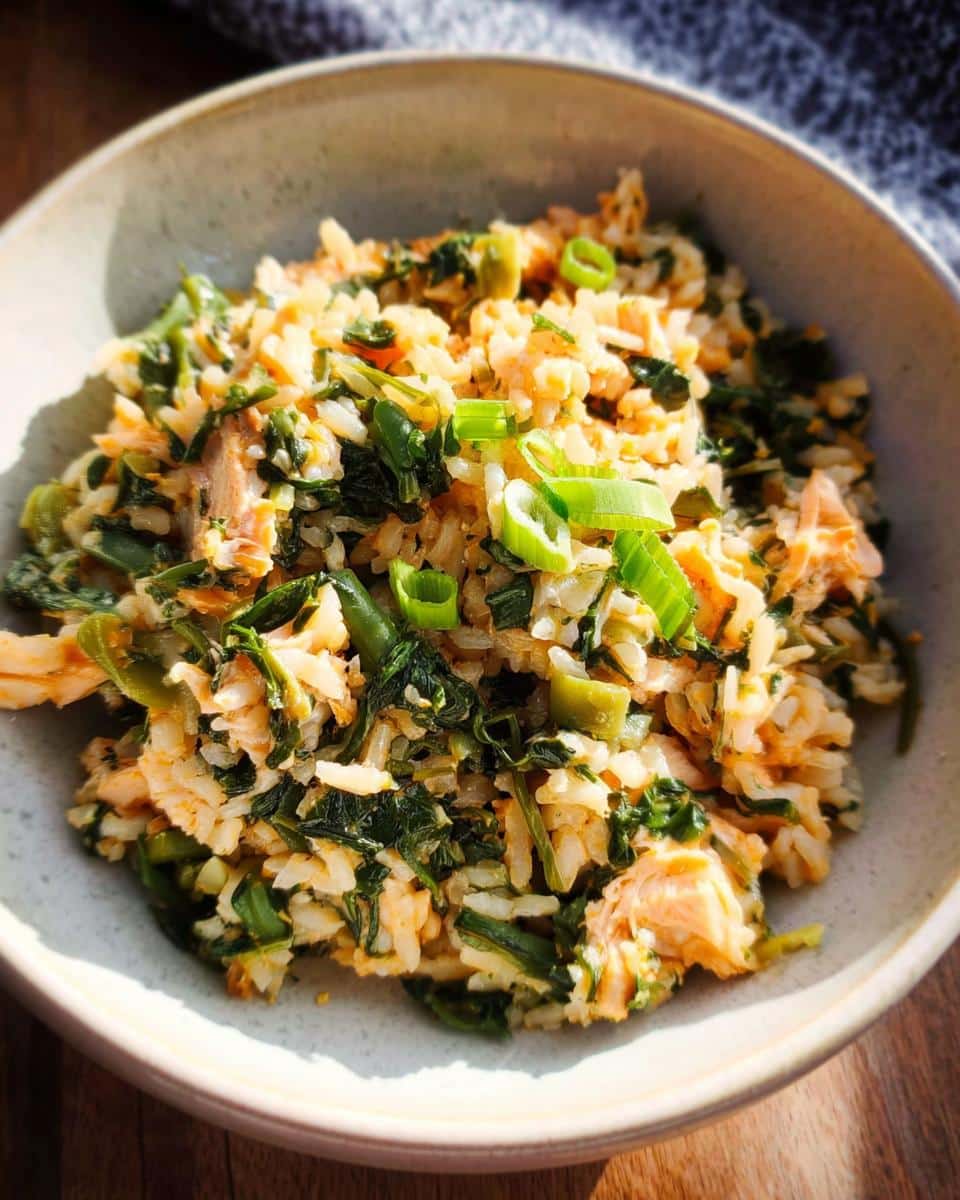 Close-up of a bowl containing Cod Spinach Winter Dog Stew mixed with rice and topped with green onions.