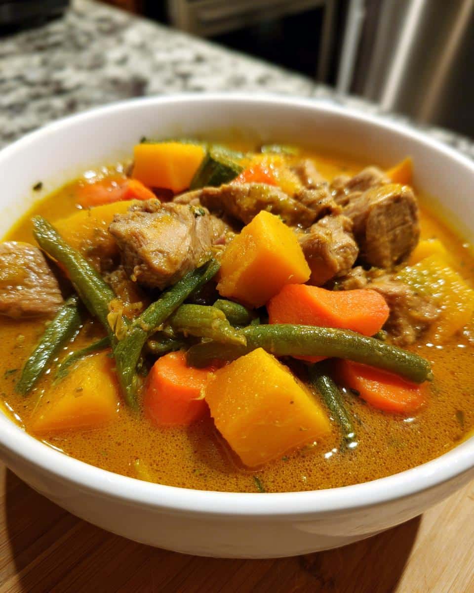 Close-up of a white bowl filled with Duck Pumpkin Grain-Free Dog Stew, featuring chunks of duck meat, pumpkin, carrots, and green beans in a rich broth.