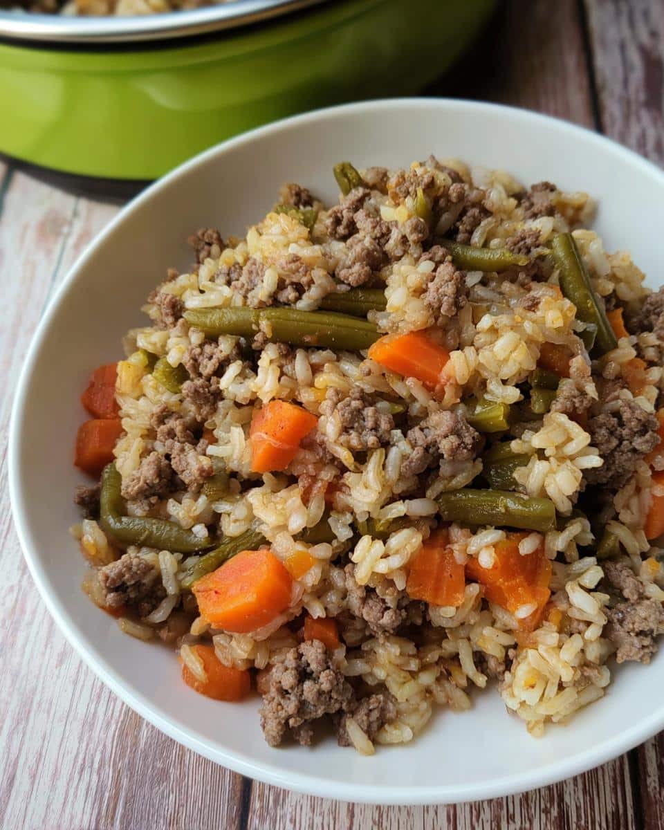 A white bowl filled with Holiday Lamb Rice Dog Platter, featuring ground meat, rice, carrots, and green beans.