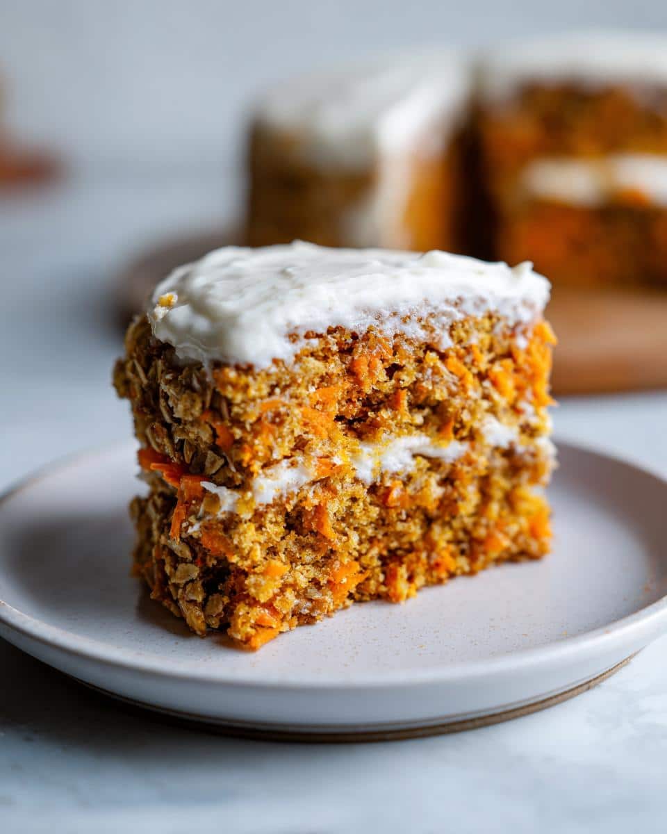 Close-up of a slice of Sweet Potato & Oatmeal Dog Cake, showing two layers with white frosting.