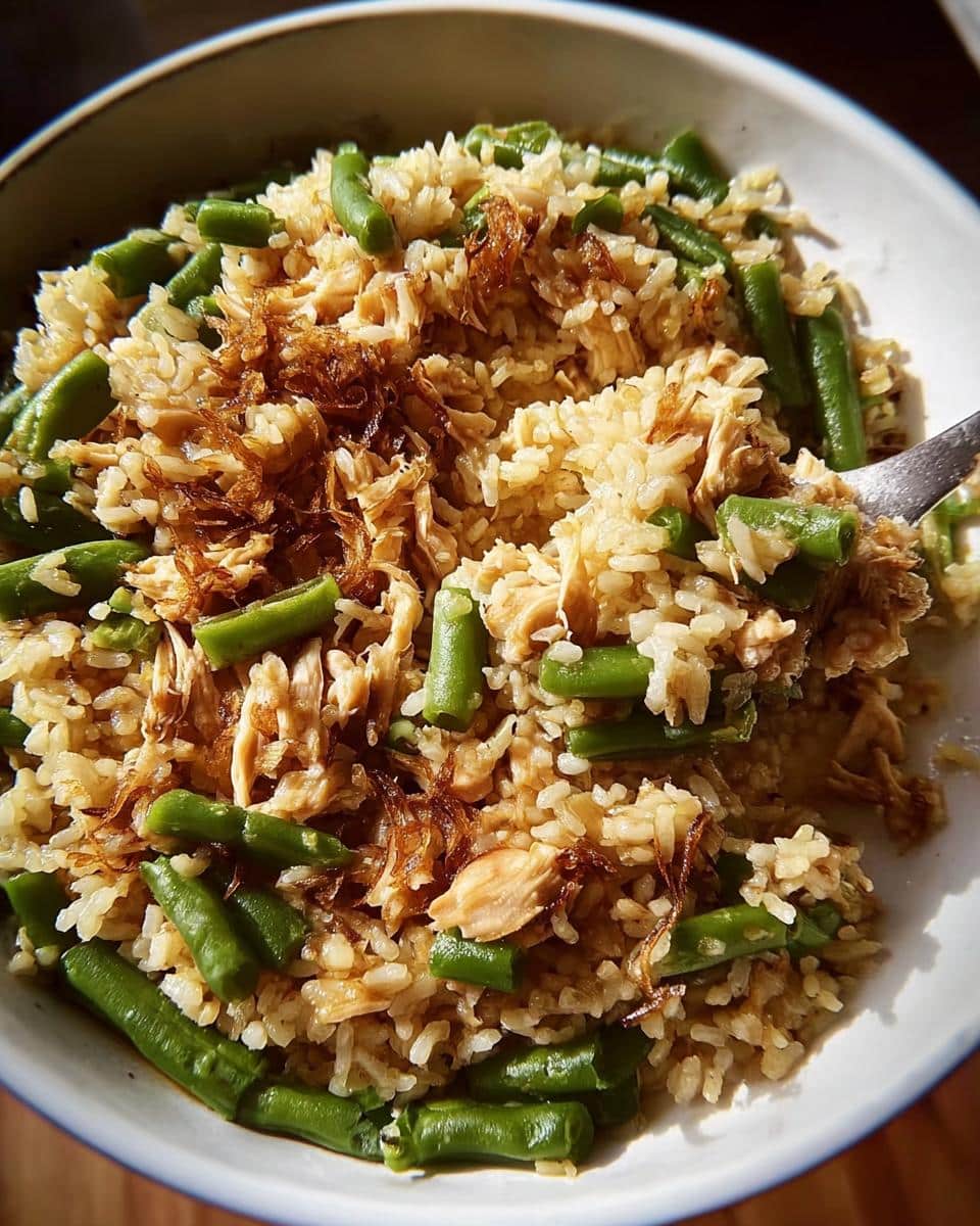 Close-up of a bowl filled with Big-Batch Chicken & Brown Rice Homemade Dog Food, showing shredded chicken, brown rice, and green beans.