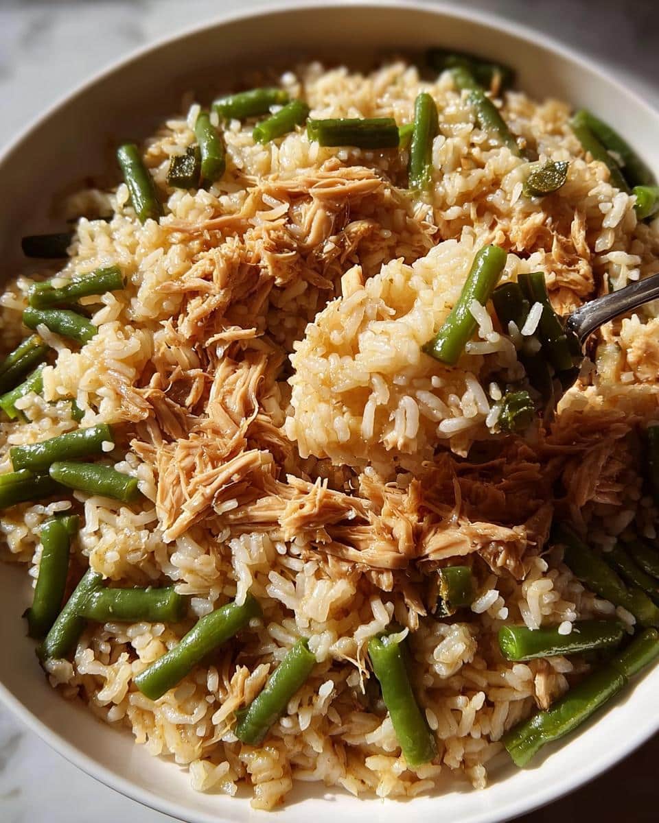 Close-up of a bowl filled with Big-Batch Chicken & Brown Rice Homemade Dog Food, featuring shredded chicken, rice, and green beans.