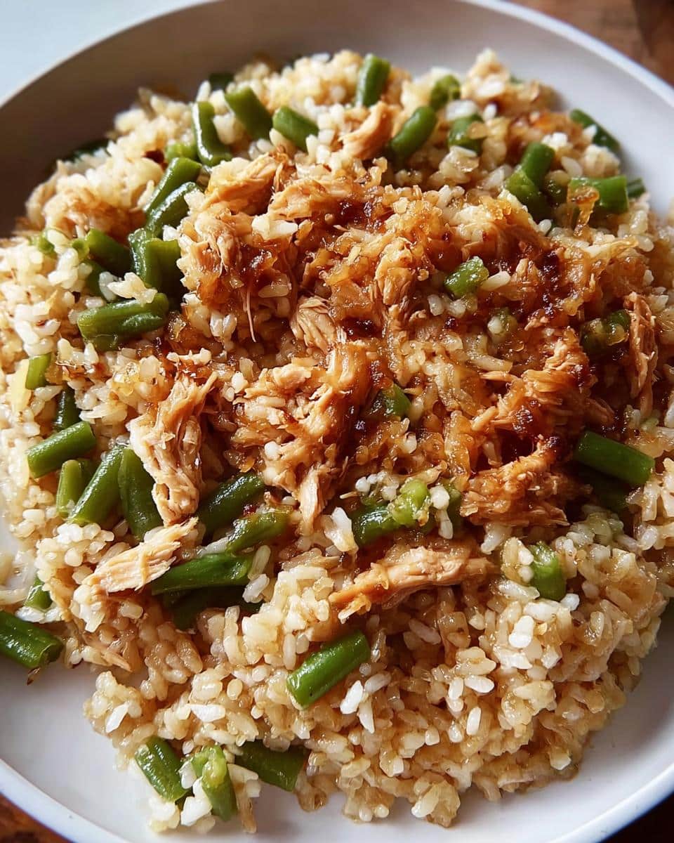 Close-up of a serving of Big-Batch Chicken & Brown Rice Homemade Dog Food, featuring shredded chicken, brown rice, and green beans.