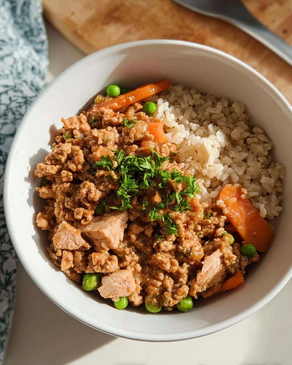 A white bowl containing Chicken & Vegetable Stew for Puppies served alongside brown rice, garnished with peas, carrots, and parsley.