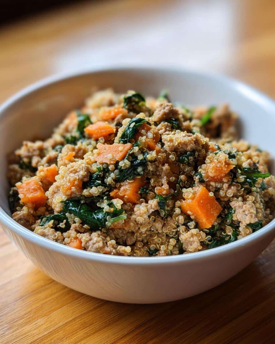 Close-up of a white bowl filled with Turkey, Quinoa & Carrots Homemade Dog Food mixture.