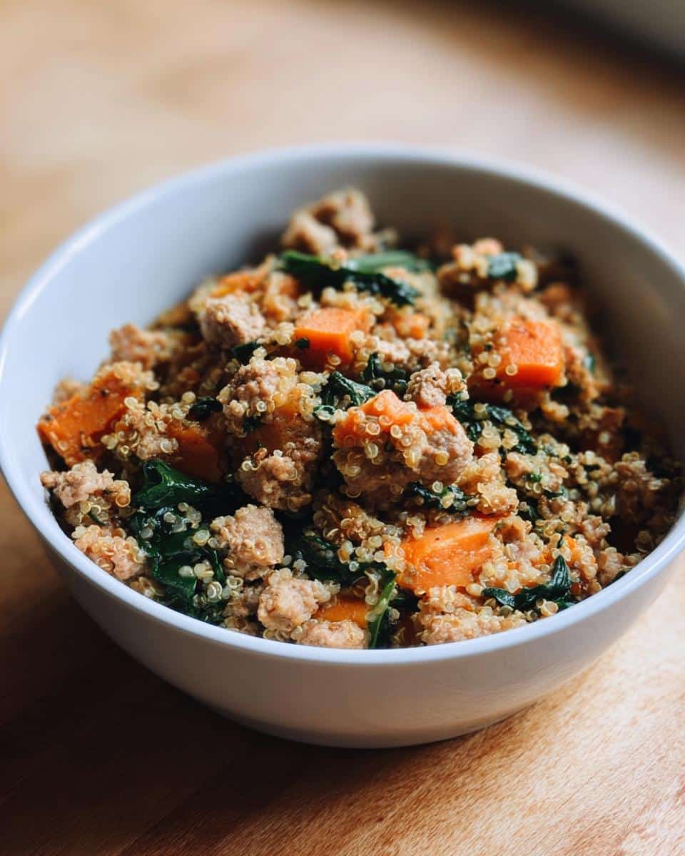 Close-up of a white bowl filled with homemade Venison, Quinoa & Spinach Dog Food mixture.