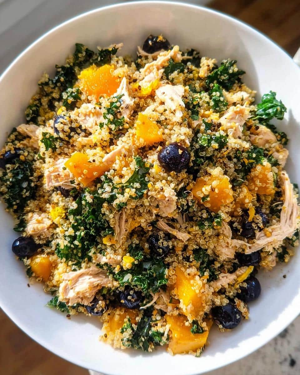 A bowl of homemade dog food featuring Pork, Quinoa & Pumpkin, mixed with blueberries and kale.